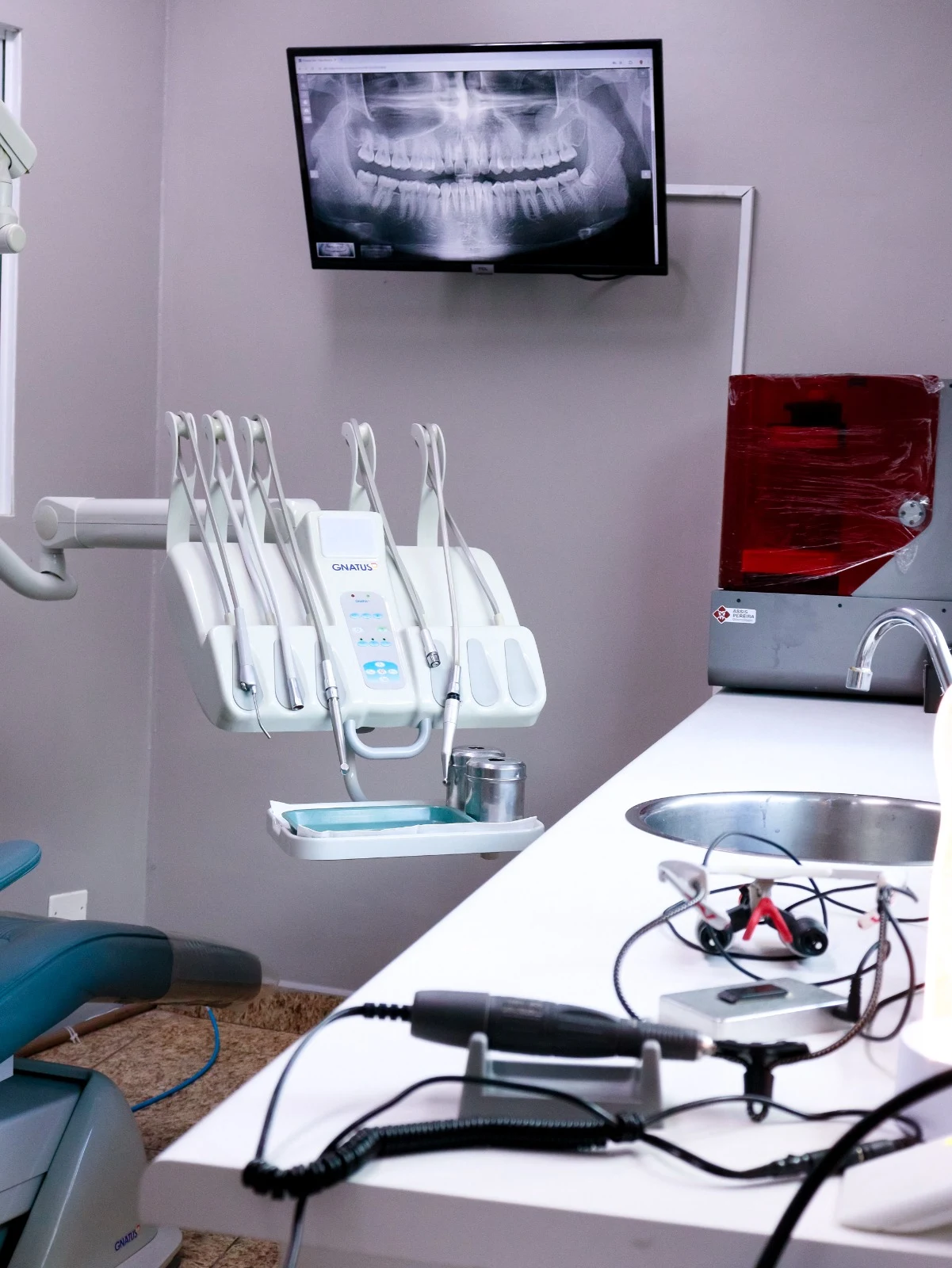 Cadeira odontológica, instrumentos e monitor do consultório